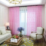 Salon élégant avec rideaux roses, apportant une touche de couleur vive à la pièce. Mobilier confortable, comprenant un canapé blanc et un fauteuil coordonné. Une table basse en bois au centre avec des décorations, tandis qu'un lustre doré illumine l'espace. Atmosphère accueillante et moderne, idéale pour un intérieur harmonieux.