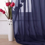 Rideau élégant en bleu marine avec vase décoratif blanc et tulipes rouges. Accessoire de décoration intérieure idéal pour un salon raffiné. Ambiance moderne et chic, parfait pour filtrer doucement la lumière du jour.
