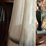 Rideau élégant en ton beige ajoutant une touche chaleureuse à un intérieur classique, accompagné d'une statue décorative unique sur une table en bois. Ambiance cosy et raffinée pour salon ou chambre. Idée déco pour une atmosphère accueillante et personnalisée.