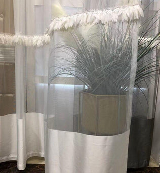 Rideau blanc élégant pour salon avec détails décoratifs, parfait pour ajouter une touche de légèreté et de sophistication à votre intérieur. Idéal pour les fenêtres de salon ou chambre, assurant une ambiance apaisante et lumineuse. Accessoire déco incontournable pour un style moderne et raffiné, s'adaptant à différents types de décoration d'intérieur.