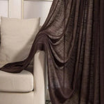 Rideau marron élégant drapé sur un canapé beige dans un salon moderne, ajoutant une touche chaleureuse et sophistiquée à la décoration intérieure.