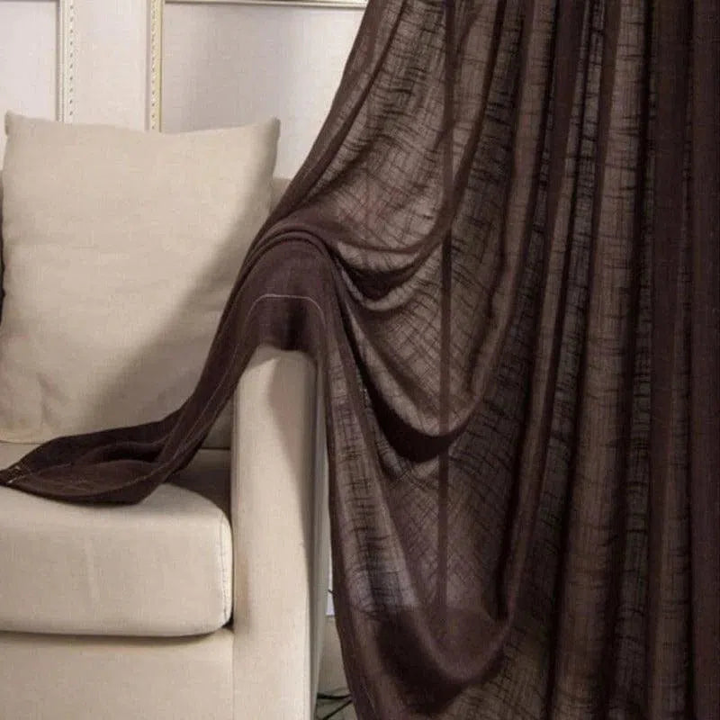 Rideau marron élégant drapé sur un canapé beige dans un salon moderne, ajoutant une touche chaleureuse et sophistiquée à la décoration intérieure.