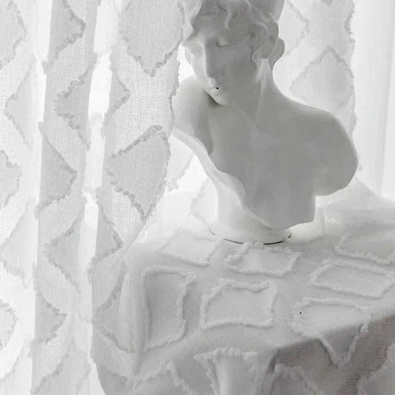Buste décoratif en blanc élégant, posé sur une table recouverte d'un tissu au motif géométrique raffiné. Accessoire idéal pour ajouter une touche artistique et sophistiquée à votre intérieur, combinant style classique et contemporain. Parfait pour le salon, la chambre ou l'entrée, ce buste apporte une atmosphère sereine et esthétique.