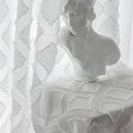 Buste décoratif en blanc élégant, posé sur une table recouverte d'un tissu au motif géométrique raffiné. Accessoire idéal pour ajouter une touche artistique et sophistiquée à votre intérieur, combinant style classique et contemporain. Parfait pour le salon, la chambre ou l'entrée, ce buste apporte une atmosphère sereine et esthétique.