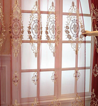 Rideaux élégants avec broderie dorée sur fond rose, idéal pour ajouter une touche de sophistication à votre intérieur. Ces voilages décoratifs conviennent parfaitement à une décoration de salon ou de chambre, offrant à la fois intimité et style. Effet lumineux et design floral chic pour embellir vos fenêtres avec raffinement.