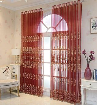Rideaux élégants translucides couleur bordeaux ornés de motifs dorés, ajoutant une touche sophistiquée à un salon lumineux avec décoration florale et mobilier classique. Parfait pour embellir vos fenêtres avec style et raffinement.